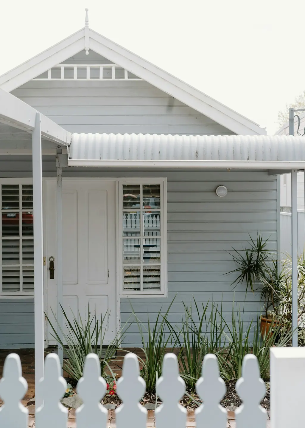 Australian weatherboard house with a sheltered verandah and picket fence