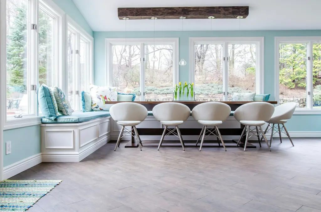 Dining room with timber beams, upholstered seating and garden-facing windows