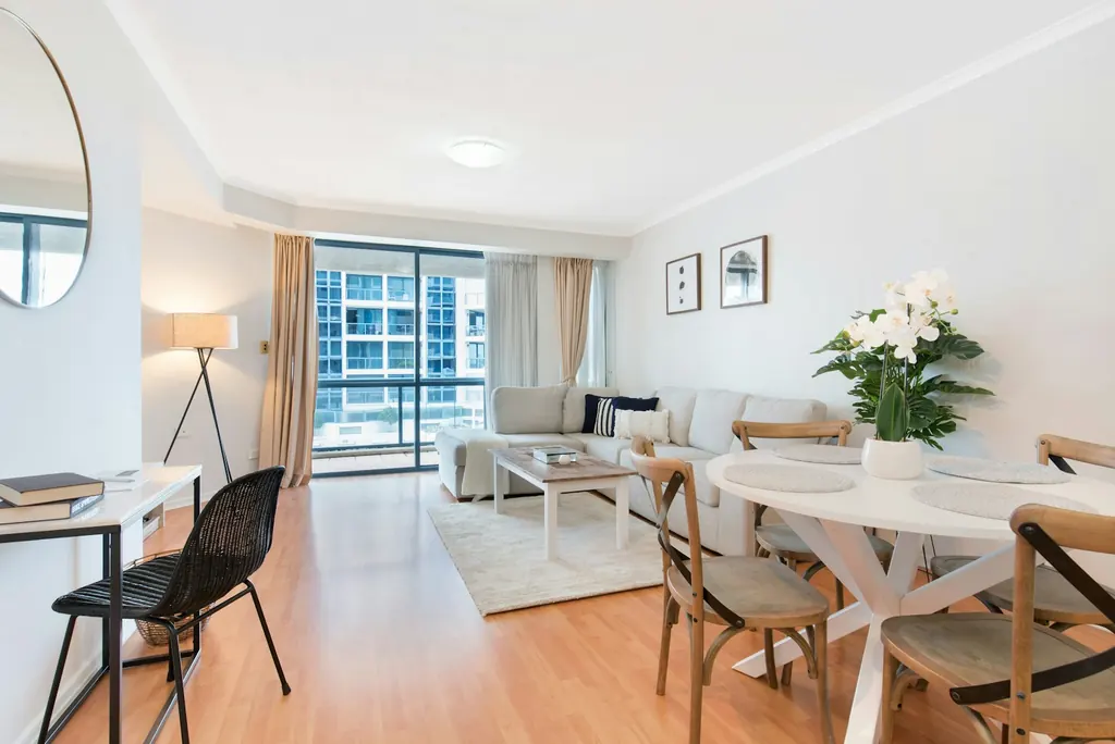 Living and dining room with timber flooring and daylight from glazed doors