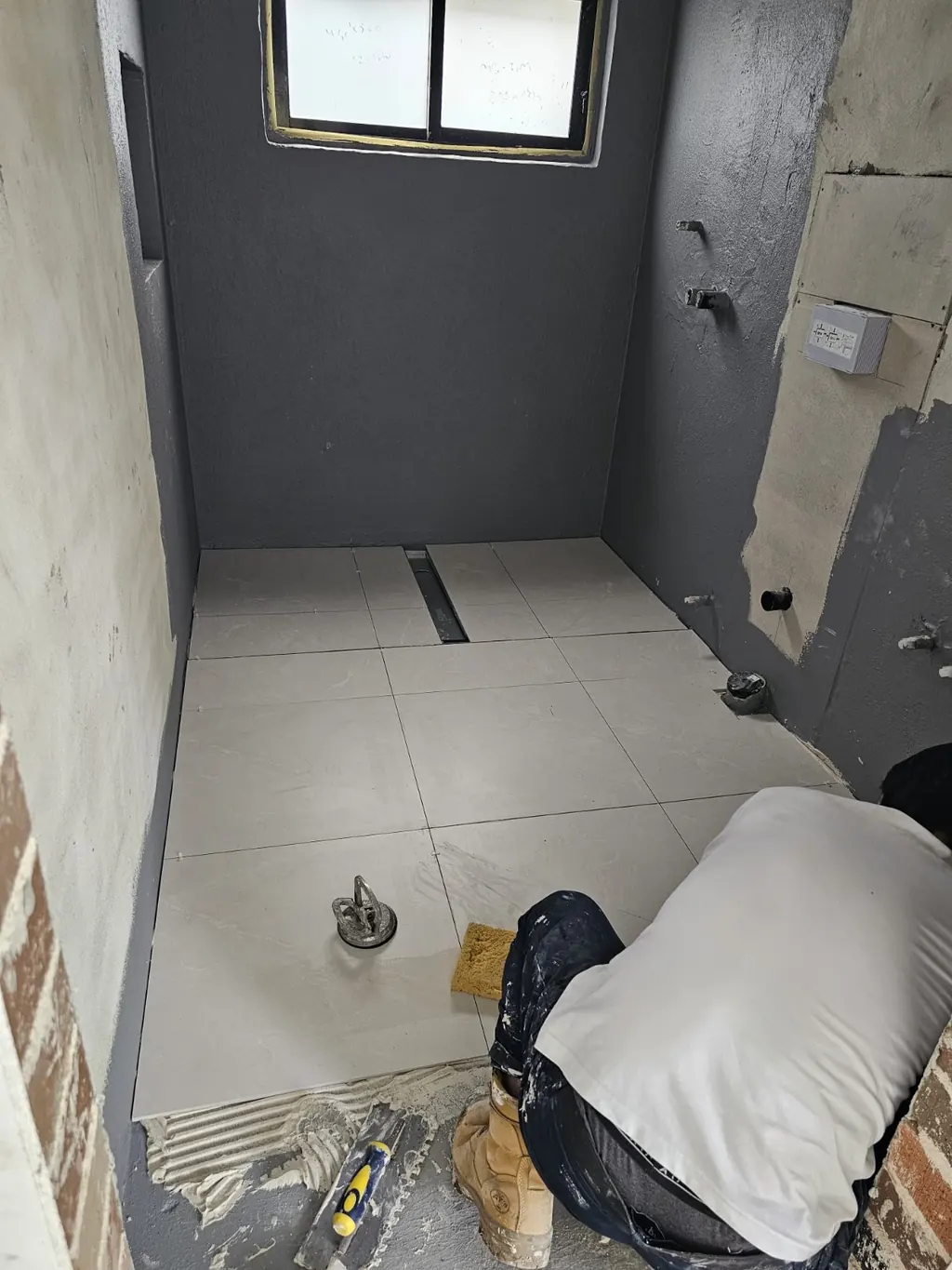 Milestone bathroom in progress with floor materials and wall preparation
