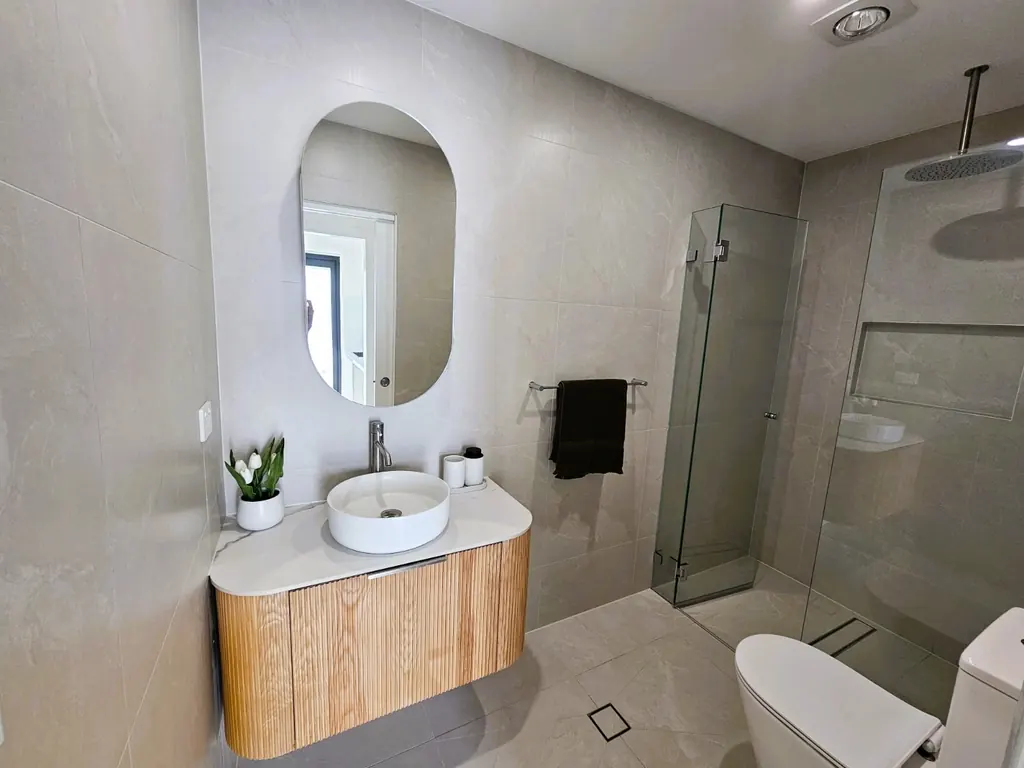 Milestone compact bathroom with a timber vanity and glazed shower
