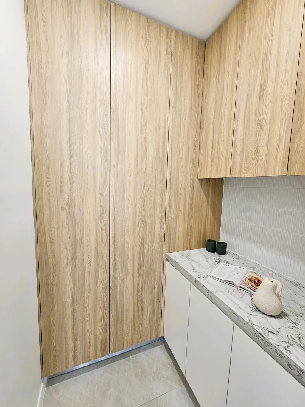 Milestone full-height timber cabinetry beside a pale worktop